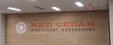 Red Cedar Investments logo on wooden wall